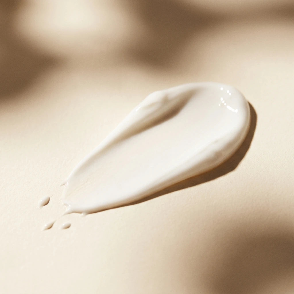 Textura cremei Ultra-Lift, dara de crema alba pe fundal crem cald